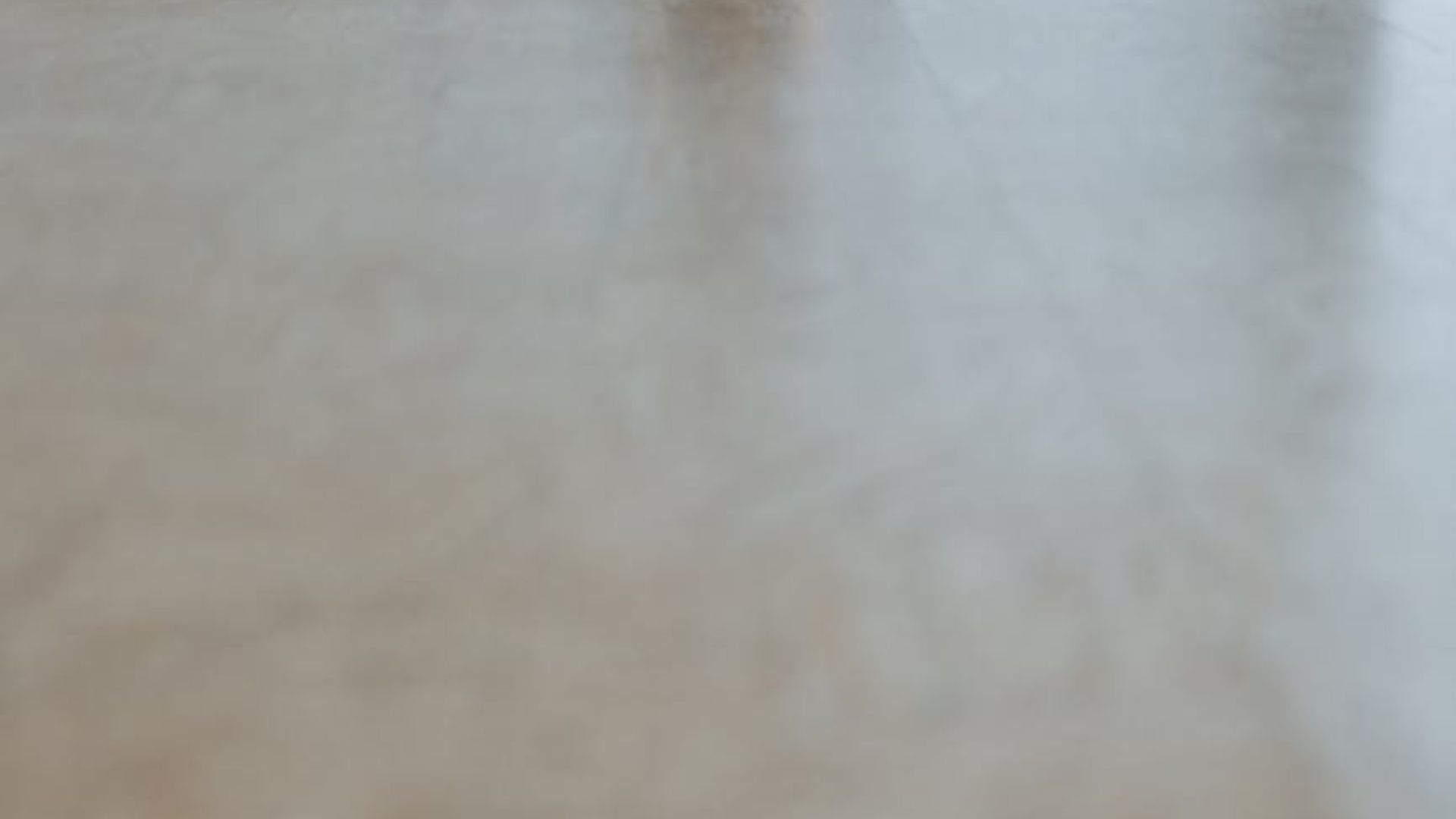 Person practicing gentle yoga in a bright minimal studio space